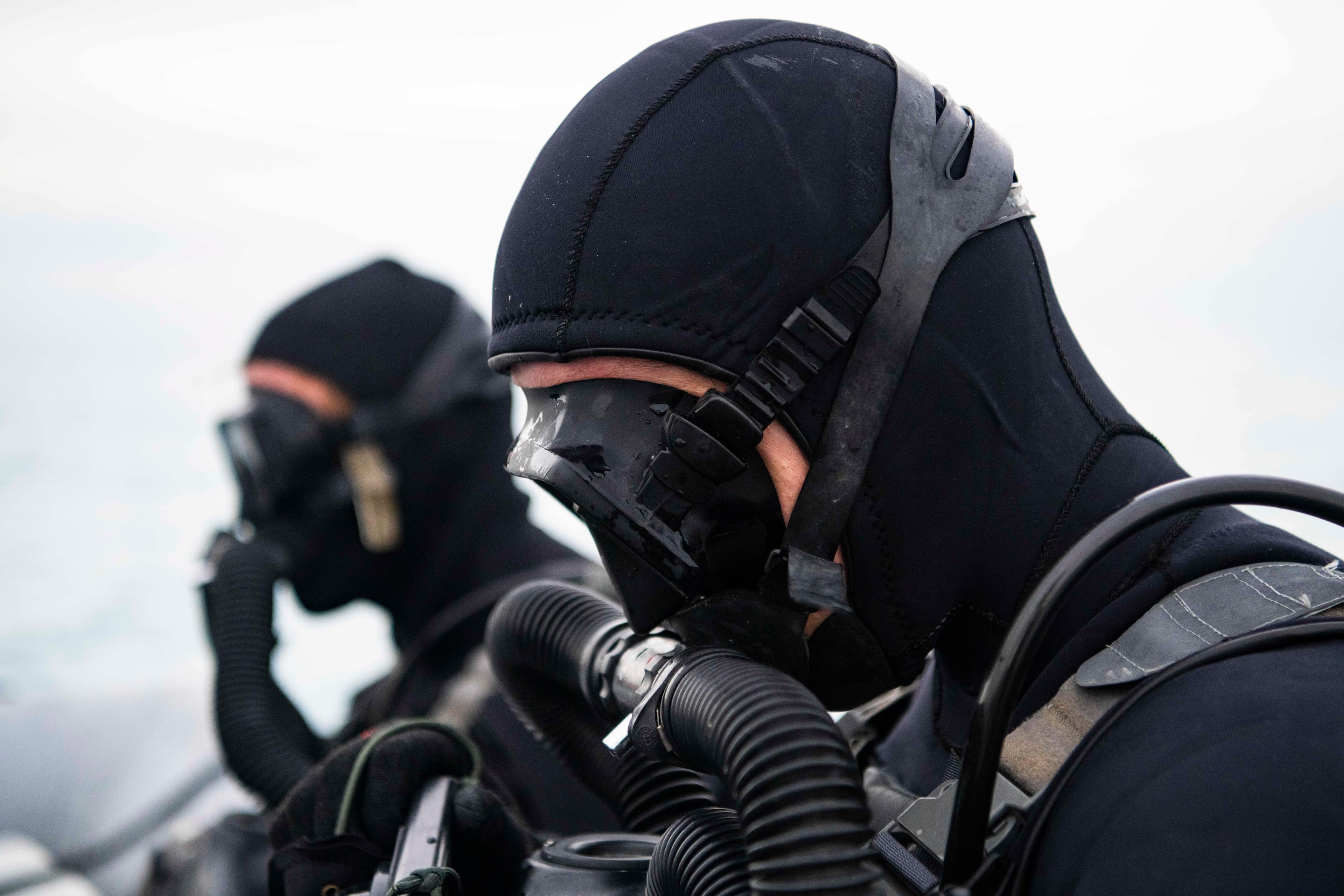 Two U.S. Naval Special Warfare divers wearing wetsuits and diving masks during training in Cyprus